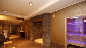 Ein Wellnessbereich mit Steinwand, Sauna und Rezeption.