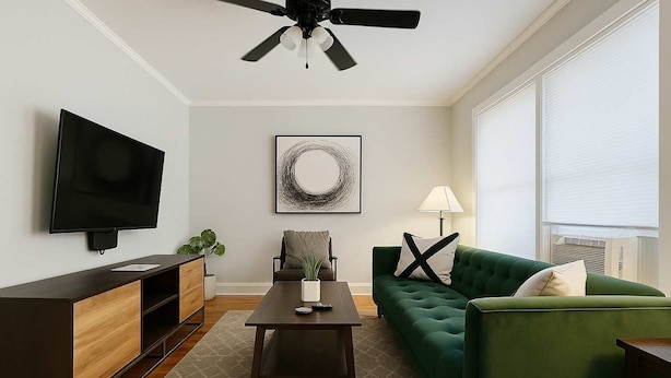 Una sala de estar moderna con un televisor de pantalla plana, un sofá verde, una mesa de centro, un aparador y un ventilador de techo.