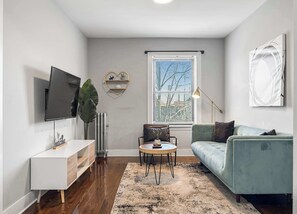 A modern living room with a TV, sofa, coffee table, and decorative items.