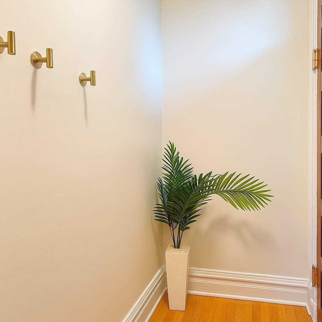 Un coin de pièce avec un mur blanc, un plancher en bois et une plante en pot.