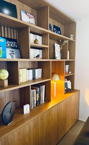 A wooden bookshelf with various books, a globe, and decorative items.