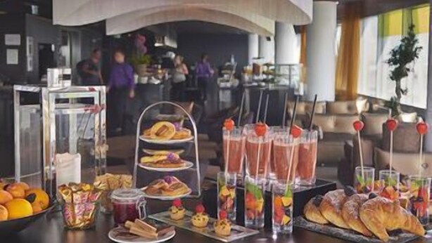 Ein Buffet mit verschiedenen Speisen, darunter Backwaren, Obst und Getränke.