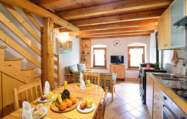 Enjoy a meal in the dining area, which features a table set for a meal, wine, and fresh fruits.