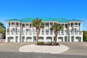 Ein mehrstöckiges Hotel mit Gründach, weißer Fassade und mehreren Balkonen.