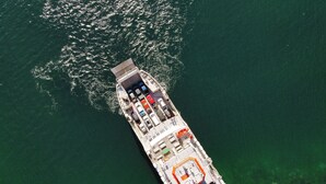 An aerial view of a cruise ship with multiple decks, including a dining area, a bar, and a pool. - The Shepherd Company (Coyhaique)