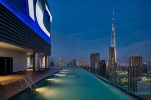 A rooftop pool with a city skyline view, including a prominent skyscraper. - Paramount Hotel Midtown (Dubai)