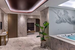 Une salle de bain moderne avec un sol en marbre, une baignoire et un lavabo fixé au mur.