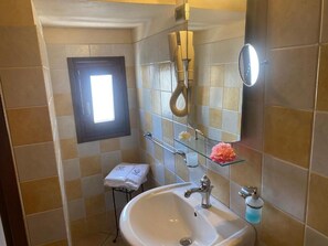 Regadera, secadora de cabello, pantuflas, toallas 