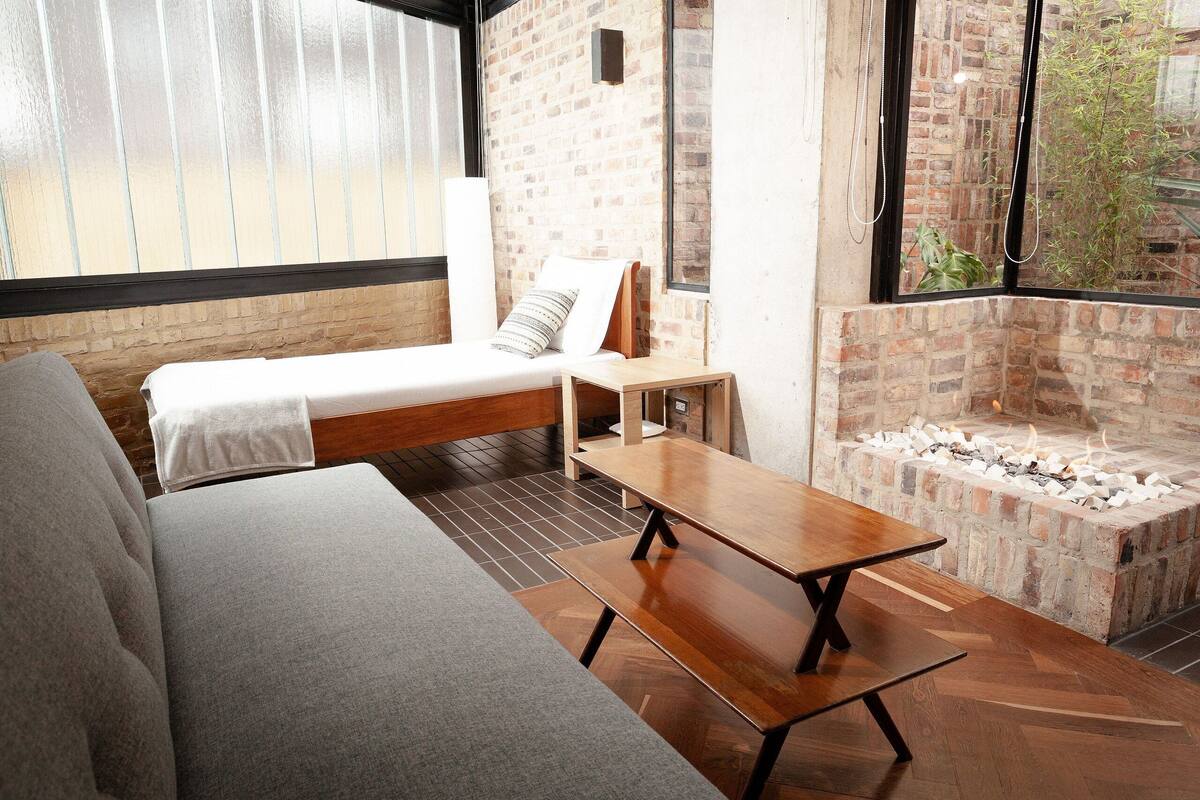 A cozy room with a sofa, a small table, and a fireplace.