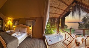 A room with a bed, a small table, a nightstand, and a view of the sea. - Perdue Hotel (Fethiye)