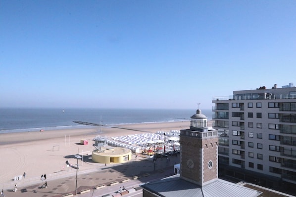 Une vue sur la plage avec une tour et un bâtiment doté de nombreuses fenêtres.