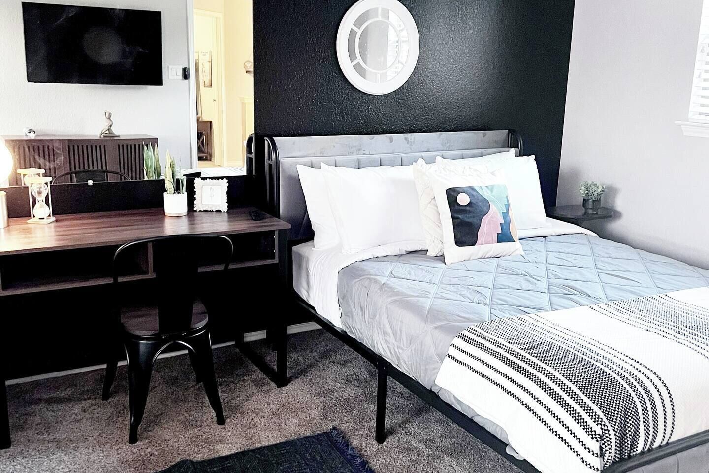 Un dormitorio moderno con cama, escritorio y silla.