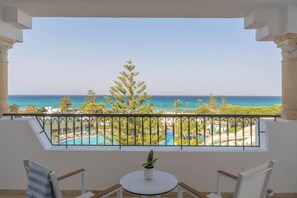 Ein Balkon mit Blick auf einen Pool und das Meer.