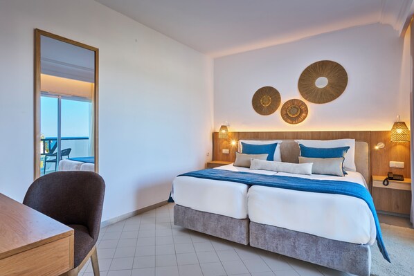 A modern hotel room with a large bed, a desk, and a balcony view. - Meliá El Mansour Mahdia (Hiboun)