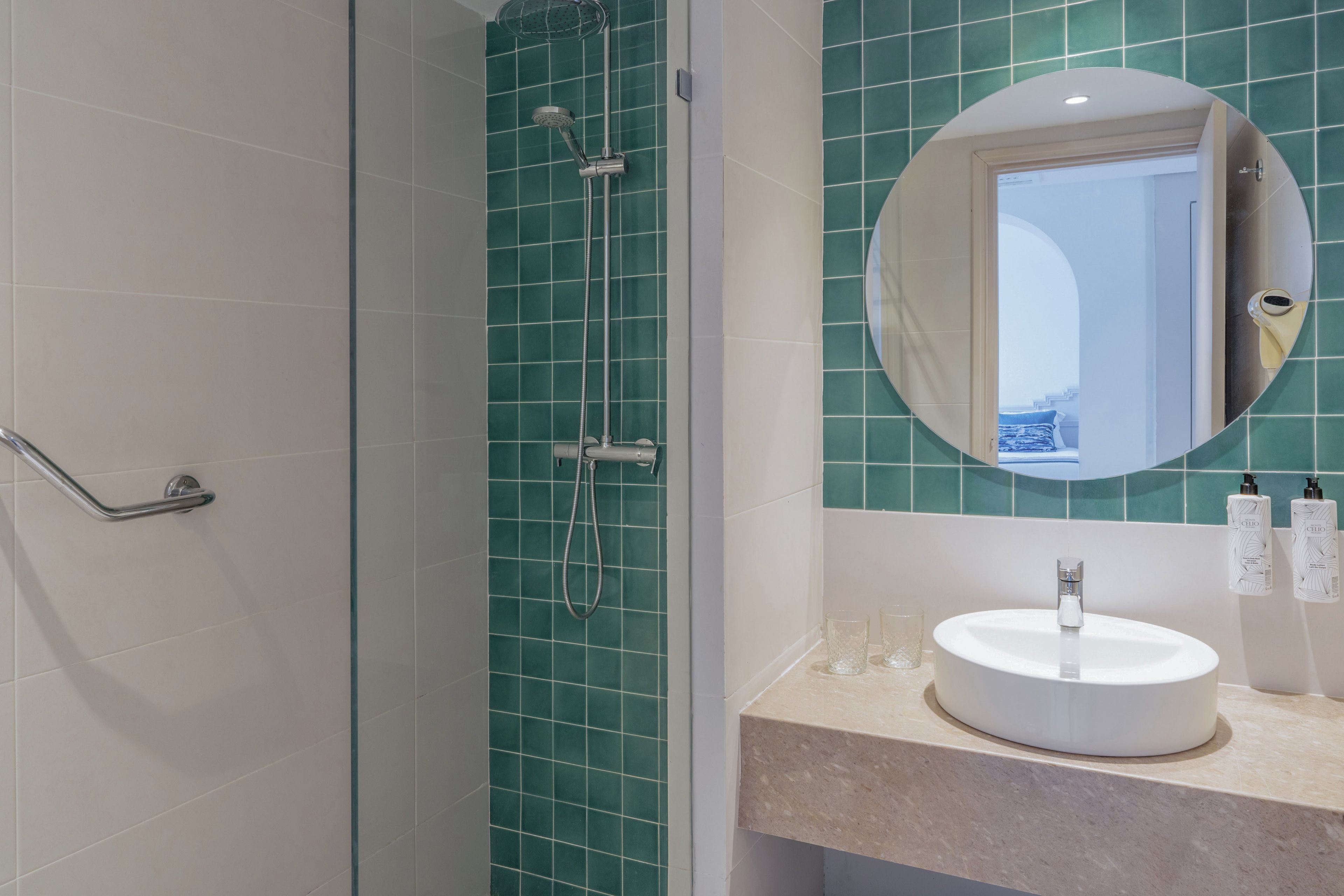 A bathroom with a shower, a sink, and a mirror.