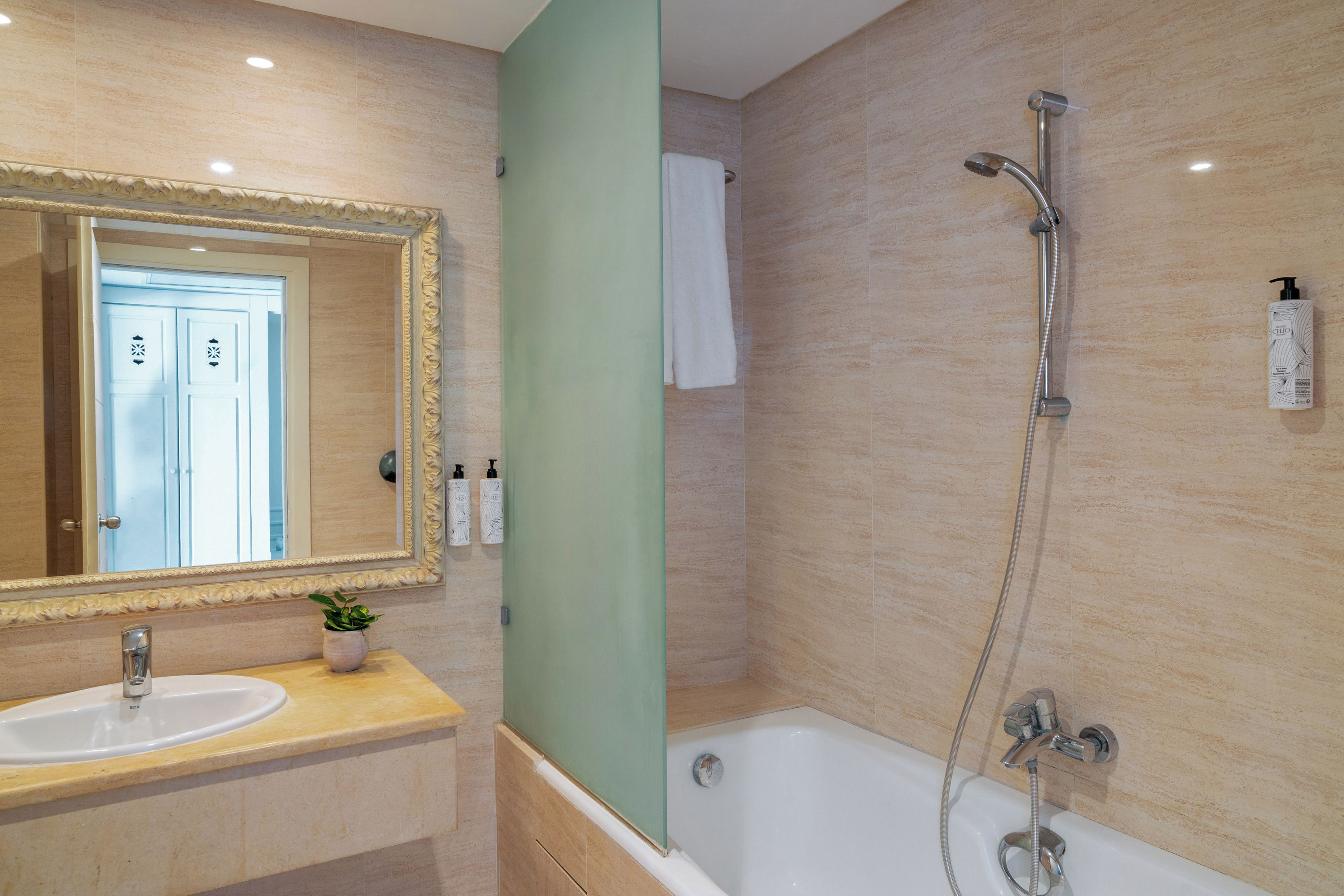 A bathroom with a bathtub, a shower, a sink, and a mirror.