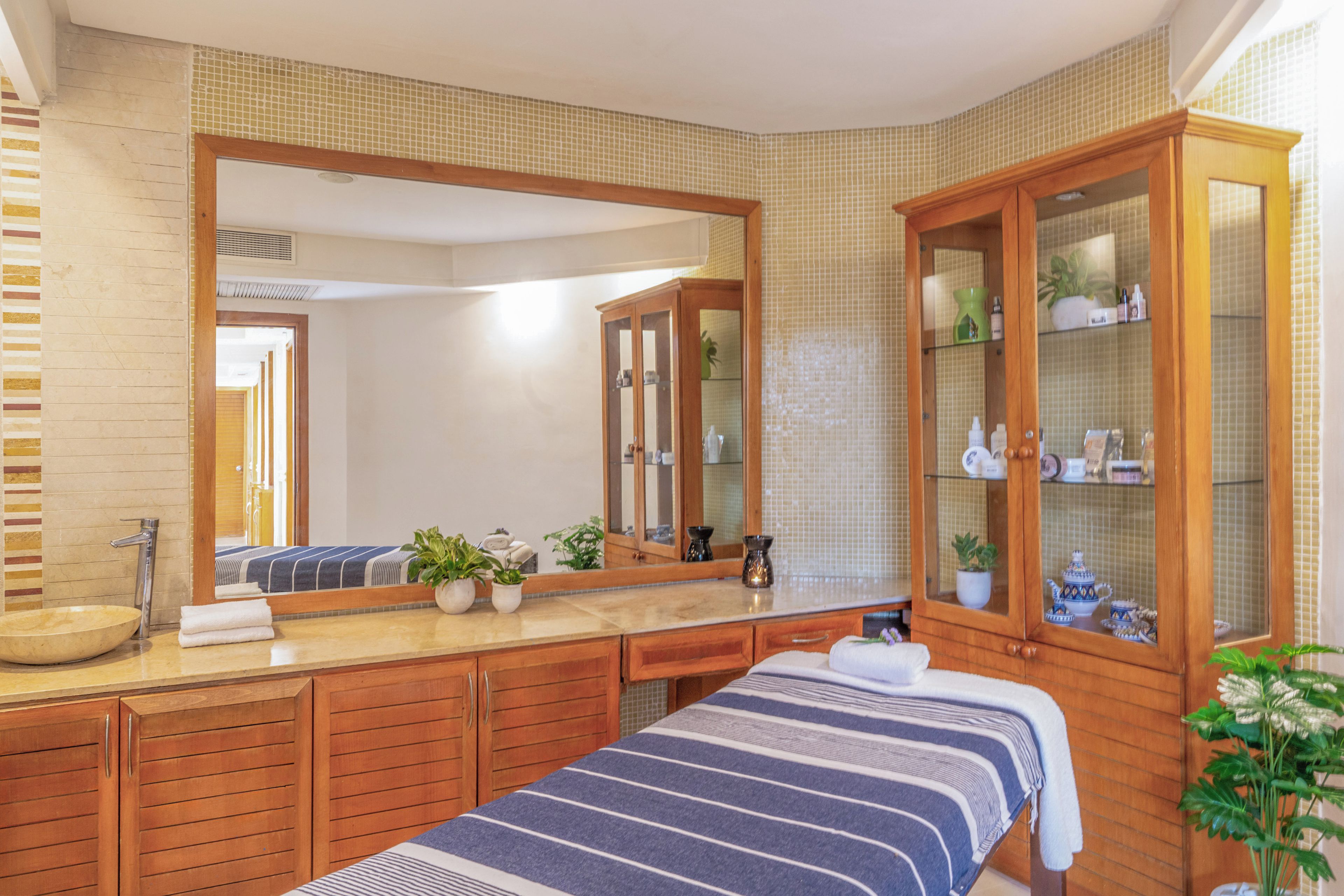 Un bagno con un ampio specchio, mobili in legno, un lavandino e un porta asciugamani.