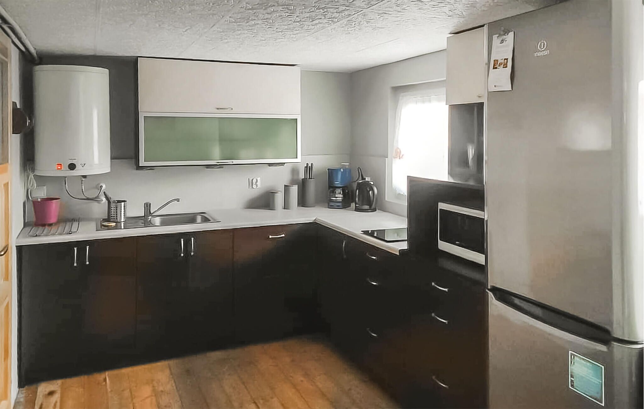 A compact kitchen with a microwave, stove, and sink.