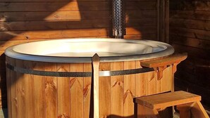 Een houten jacuzzi met een bankje en een opstapje.