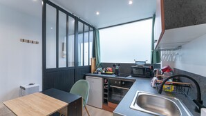 A compact kitchen with a sink, microwave, and small refrigerator.