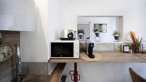 A kitchen with a microwave, toaster, coffee maker, and potted plants. - 10 mins from annecy, apartment apartment near the lake (Sevrier)