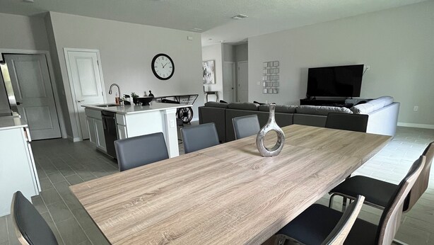 A modern kitchen with white cabinets, a black countertop, and a built-in oven.