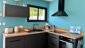 Une cuisine moderne dotée d’une fenêtre, d’appareils électroménagers intégrés et d’une hotte noire.