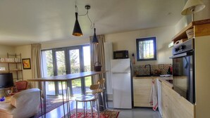A modern kitchen with a dining area, large windows, and a TV. - La Maison de Craponne (CRAPONNE)