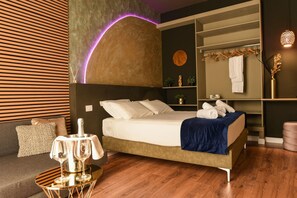 Una camera da letto moderna con un letto, un comodino e una lampada a sospensione.