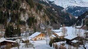 Un pueblo cubierto de nieve con casas de madera y una vista despejada de los picos circundantes.