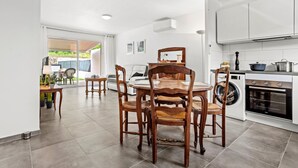A modern kitchen with a dining area, a washing machine, and a large window. - Villa 'Les Coteaux Du Soleil' with Private Pool, Wi-Fi and Air Conditioning (Carcès)