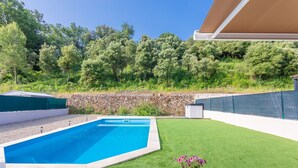 A swimming pool with a stone wall and a grassy area. - Villa 'Les Coteaux Du Soleil' with Private Pool, Wi-Fi and Air Conditioning (Carcès)