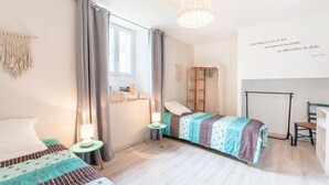 A bedroom with two beds, a desk, a chair, a hanging light fixture, and a macrame wall hanging. - Holiday Home 'Chez Bob' with Mountain View and Wi-Fi (Hèches)