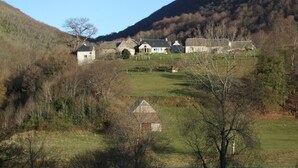 A rural village with traditional stone houses, a small church, and a hill in the background. - Holiday Home 'Chez Bob' with Mountain View and Wi-Fi (Hèches)