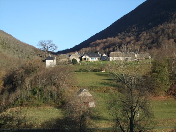A rural village with traditional stone houses, a small church, and a hill in the background. - Holiday Home 'Chez Bob' with Mountain View and Wi-Fi (Hèches)
