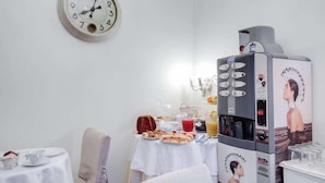 Esmorzar preparat amb rellotge, cafetera i taula plena d'aliments i begudes.