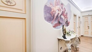 Una habitació amb un mural gran a la paret, un escriptori amb un ventilador i una porta amb interruptor de llum.