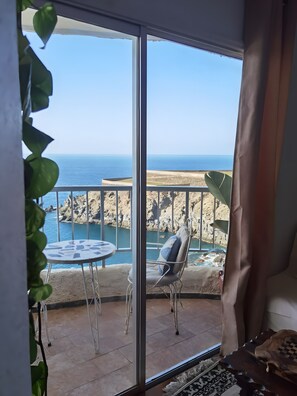 Ein Balkon mit Meerblick, einem Tisch und einem Stuhl.