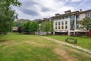 Une cour avec une pelouse verdoyante, un sentier et un banc.