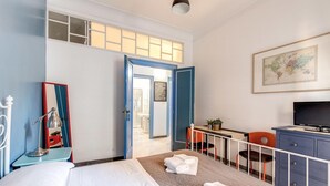 Una camera d'hotel con un letto, una scrivania, una sedia, un televisore e una mappa appesa al muro.