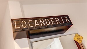 Un letrero con la palabra 'LOCANDERIA' sobre una estructura de madera.