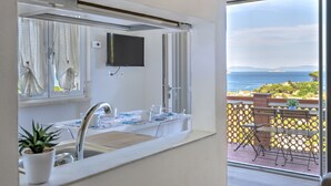 A bathroom with a sink, mirror, and potted plant.