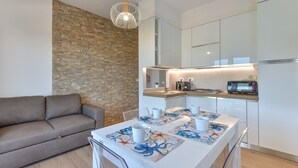 A modern kitchen with white cabinets, a built-in oven, and a microwave.