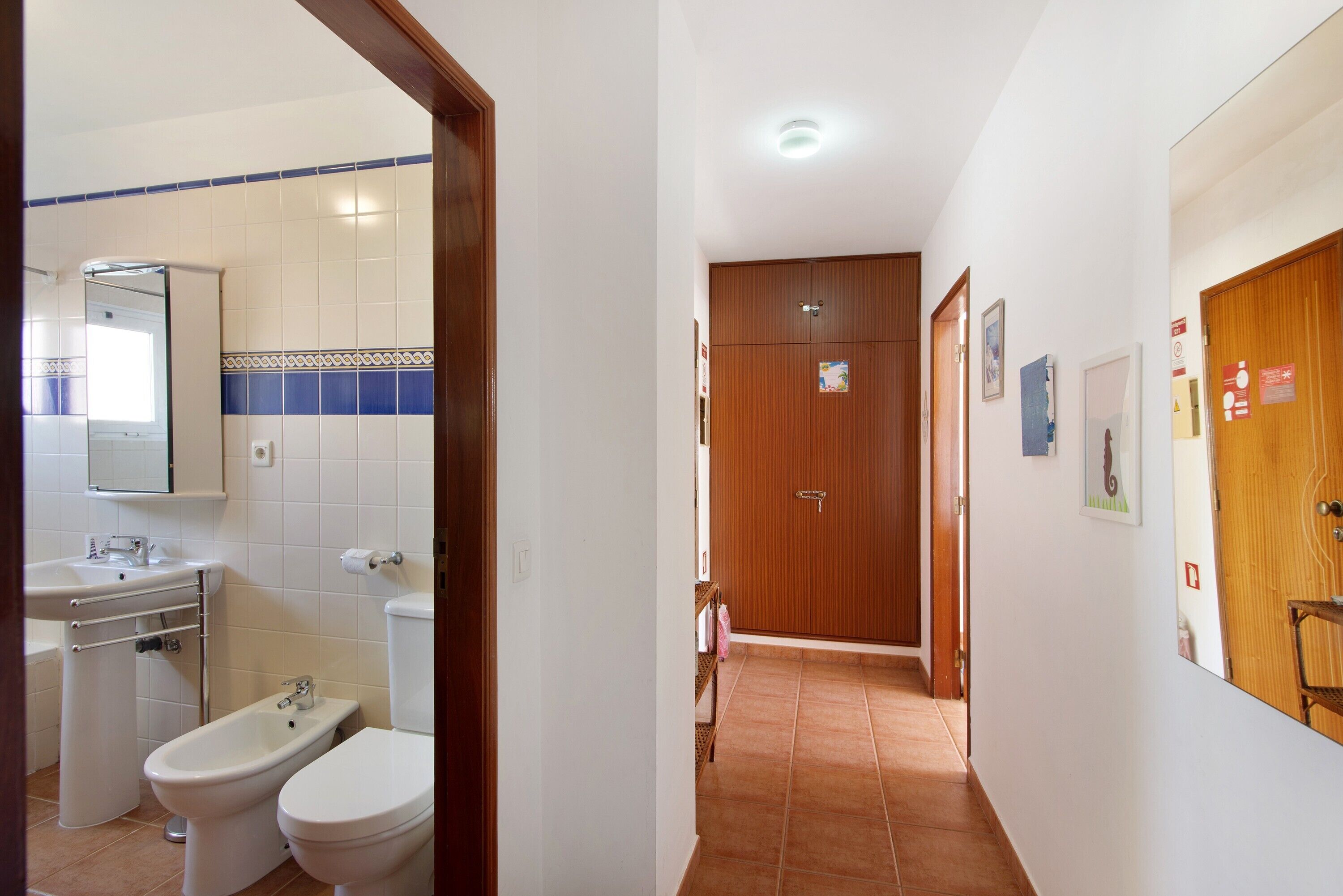 A bathroom with a sink, two toilets, and a mirror.