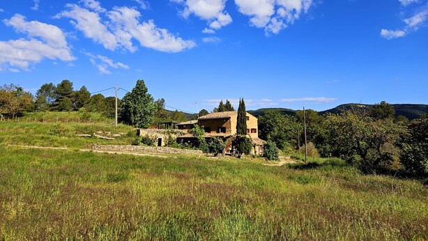 A rustic house with a stone foundation, surrounded by a lush green landscape and a clear blue sky. - Country House 'Caltiku' with Mountain View, Private Pool and Private Terrace (els Ranxos de Bonany)