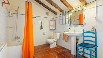 Une salle de bain équipée d’une baignoire, d’une douche, de toilettes et d’un lavabo.