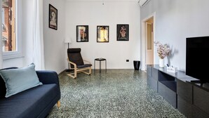 A modern living room with a sofa, chair, small table, and artwork on the wall. - La Casa Di Licia - Apartment in La Spezia (La Spezia)