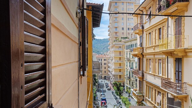 A narrow street view from a balcony, with buildings on either side and a mountain in the background. - La Casa Di Licia - Apartment in La Spezia (La Spezia)