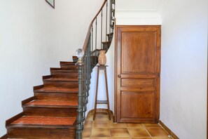 A wooden staircase with a handrail and a door at the bottom. - Country House "Maison Bourgues" with Cliff View, Wi-Fi, and Air Conditioning (Lioux)