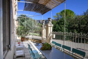 An outdoor patio with a table, chairs, and a pergola structure.